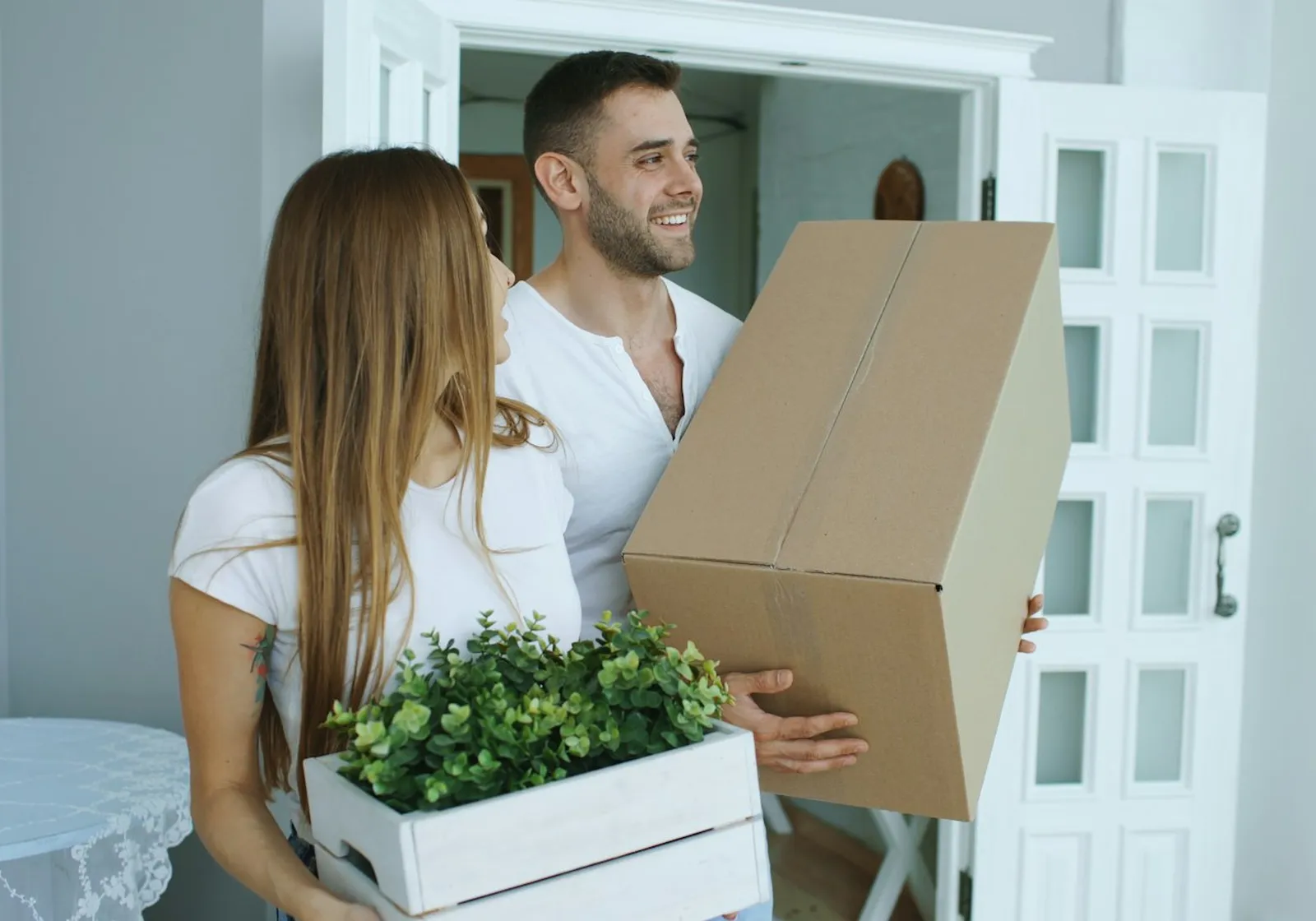 Couple carrying boxes into their new home